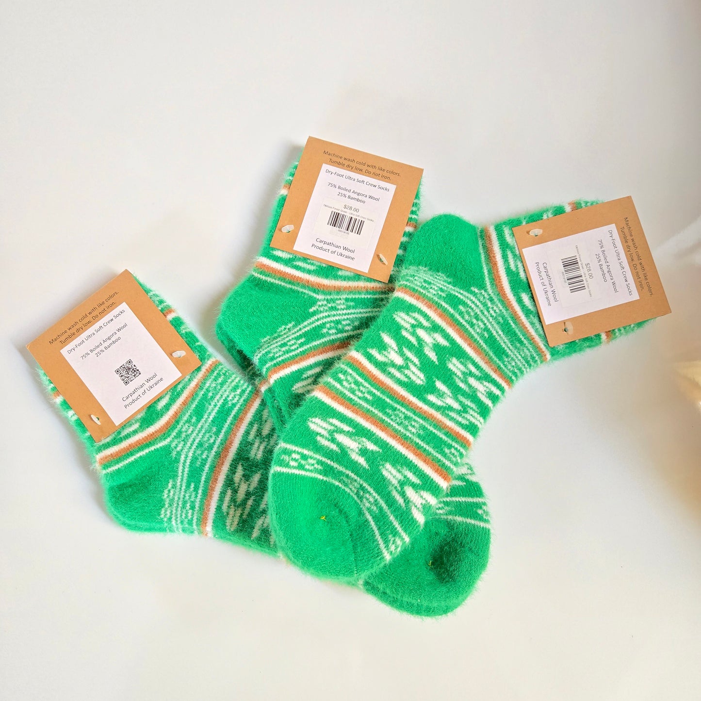 Green patterned socks with brown cardboard packaging on a white background
