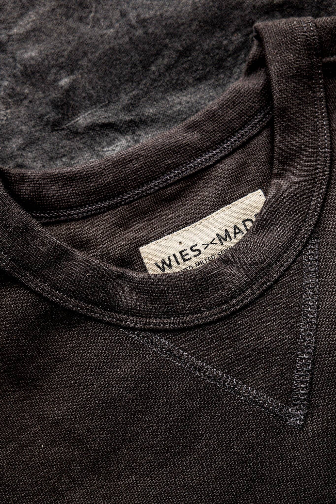 Close-up of a black garment with a visible brand label, Wies Made.
