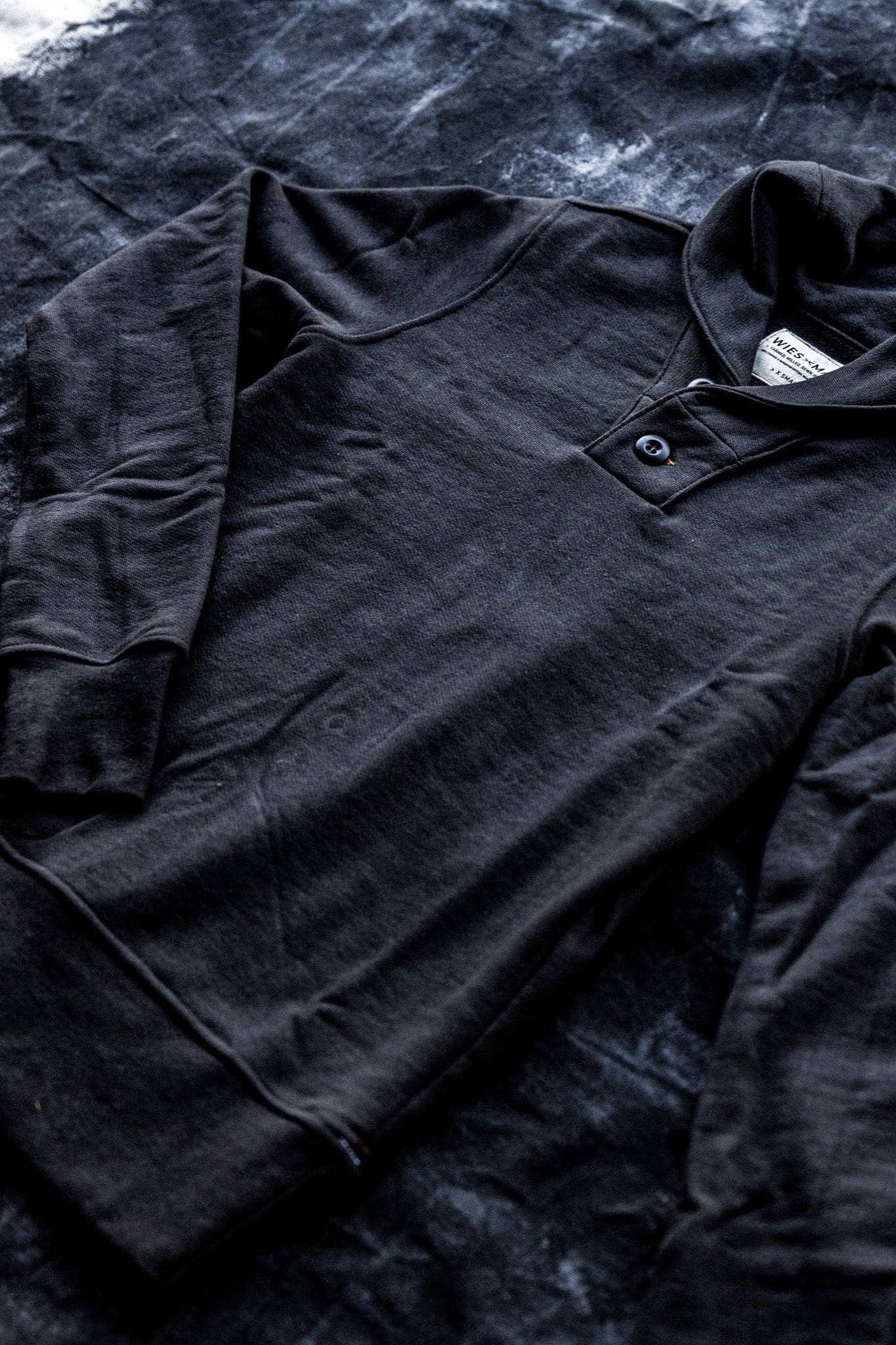 Dark gray long-sleeve shirt on a textured dark background