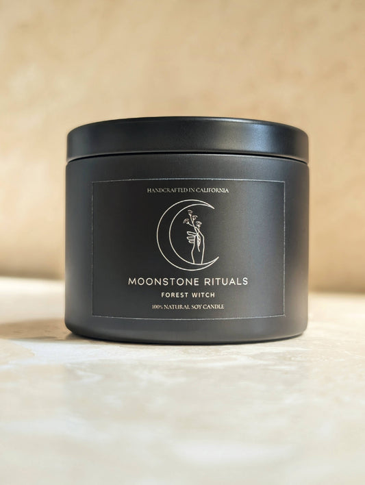 Black candle container with 'Moonstone Rituals' branding on a beige background